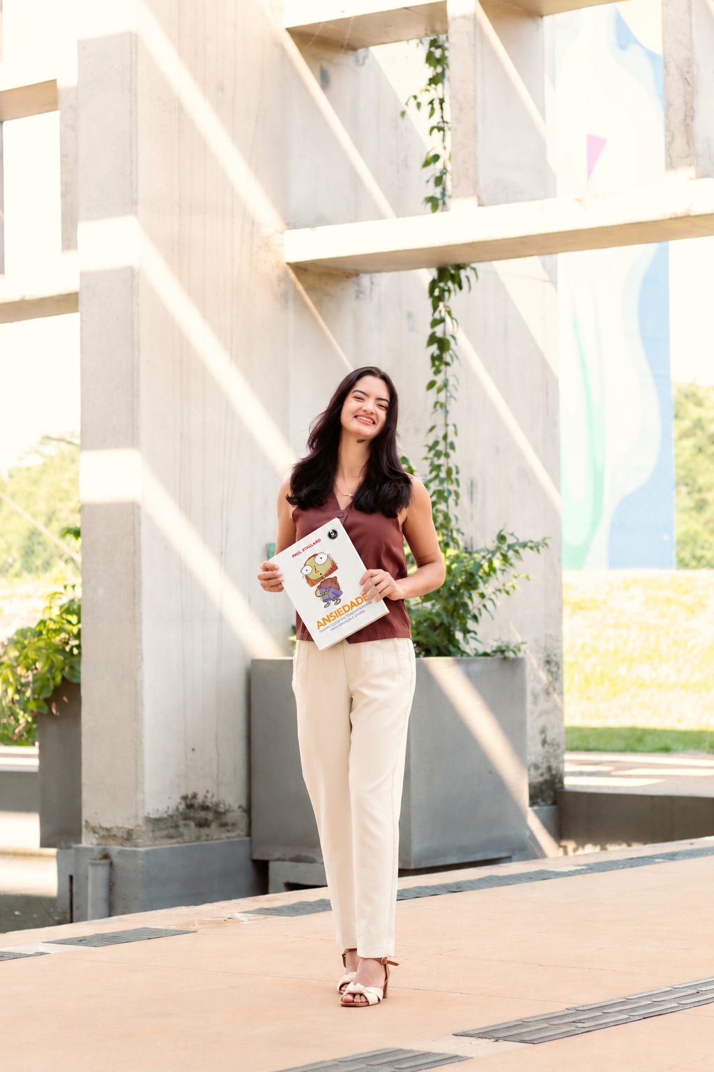 Camila Rosário sorrindo com um livro
